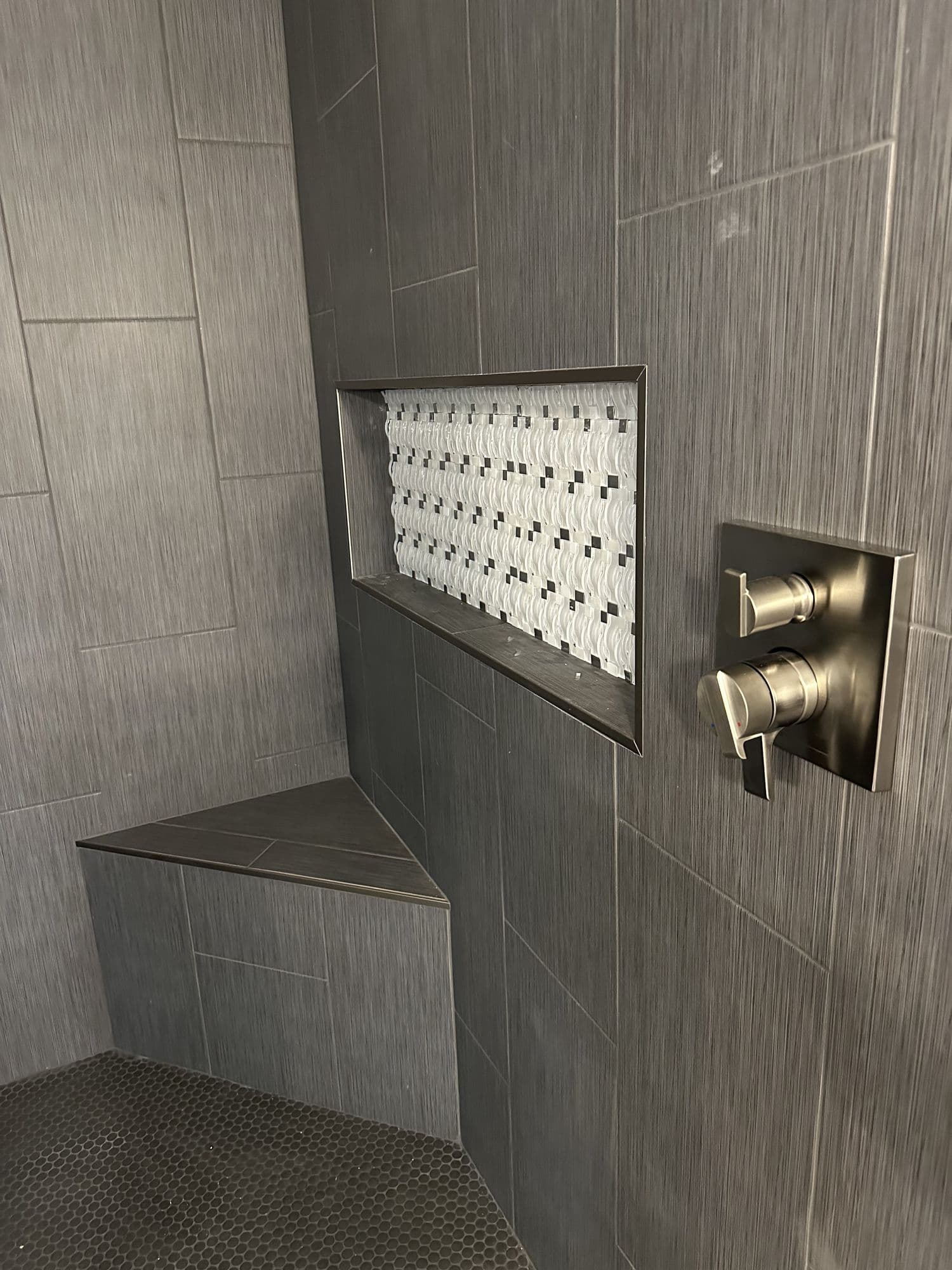 Tiled shower with a bench and recessed niche