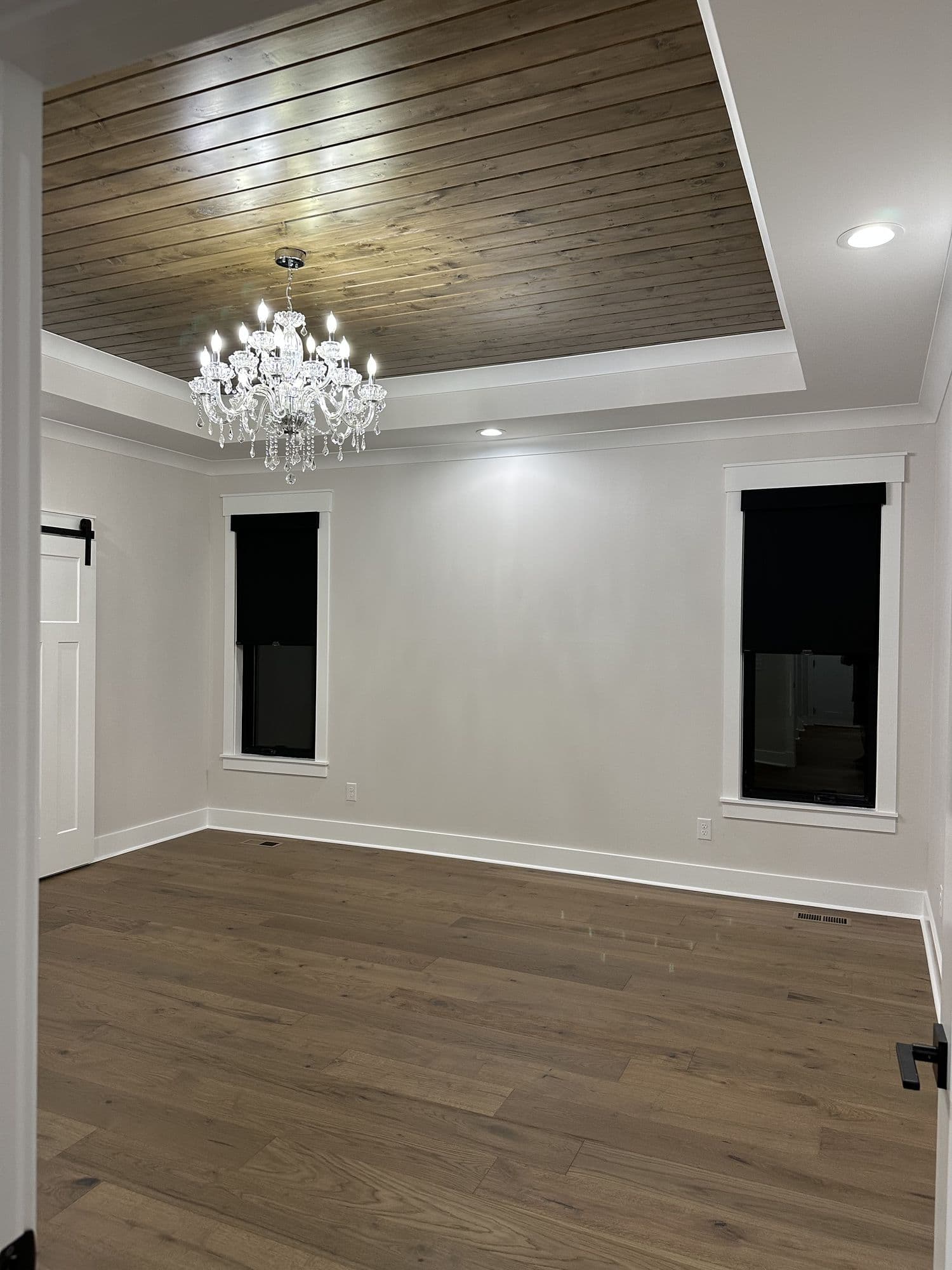 Living room with a planked tray ceiling and chandelier