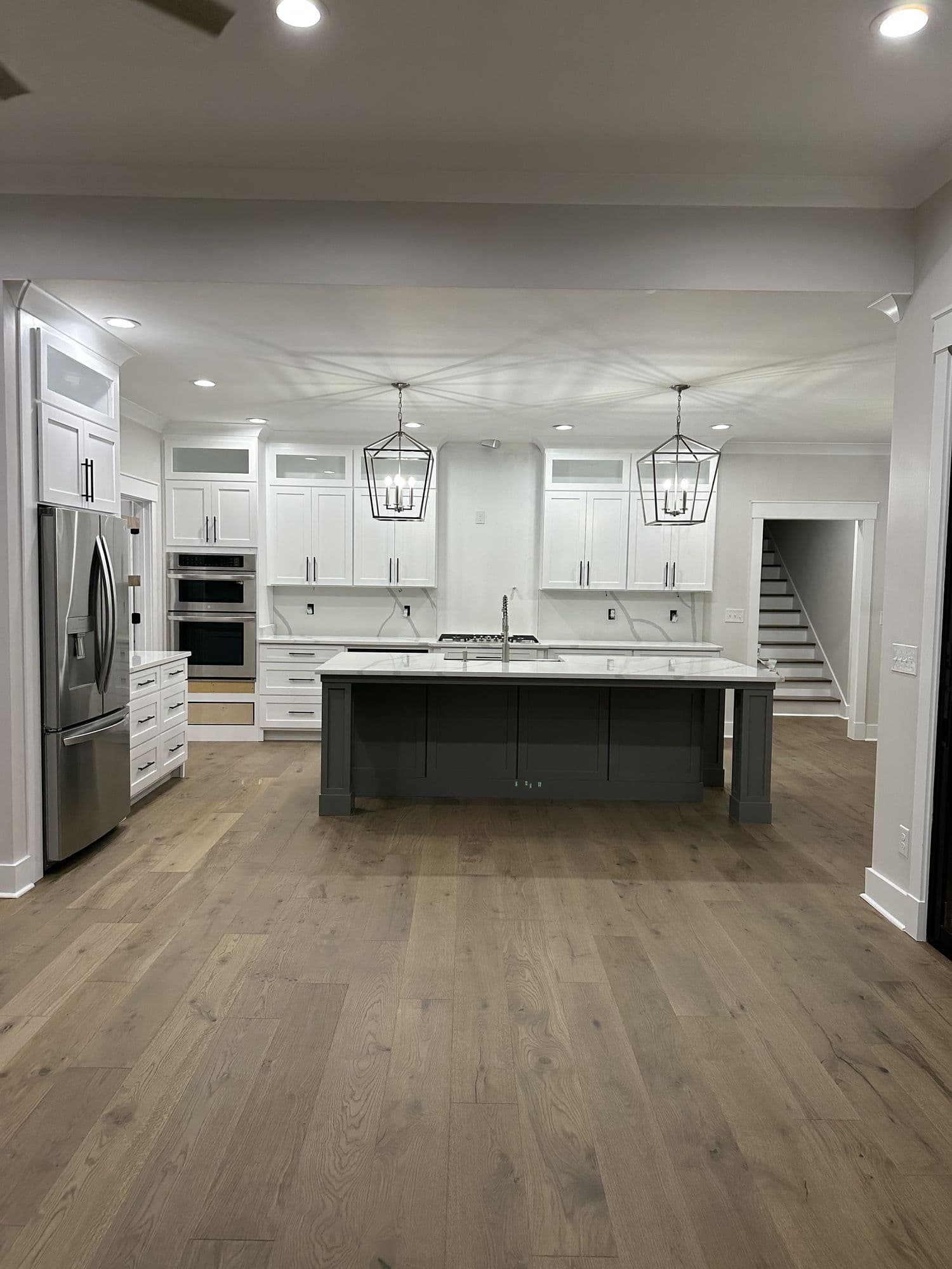 White kitchen with island and stainless appliances